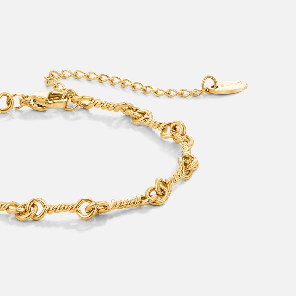 Figaro Gold Knot Chain Bracelet, close-up of a gold twisted-link chain with extender and tag