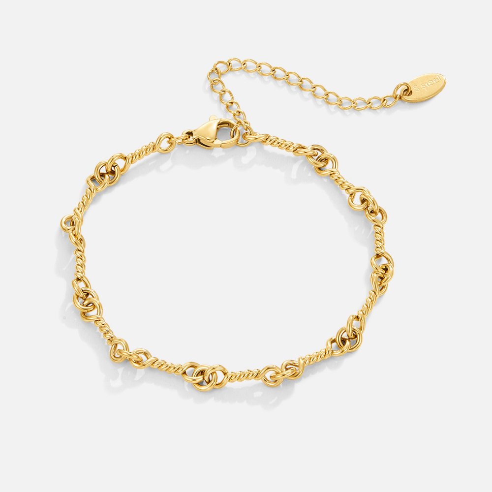 Figaro Gold Knot Chain Bracelet, gold bracelet laid flat on white, twisted links with extender chain