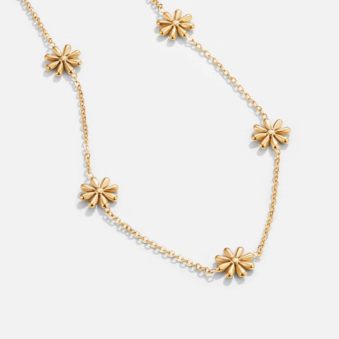 Flower Power 18K Gold Necklace, gold daisy-flower necklace laid flat on a white surface