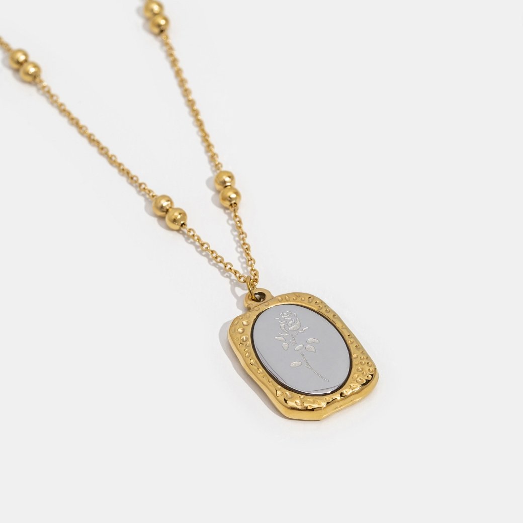 'Fragile Love' Rose Necklace, gold necklace laid flat on white, with a silver rose-engraved pendant