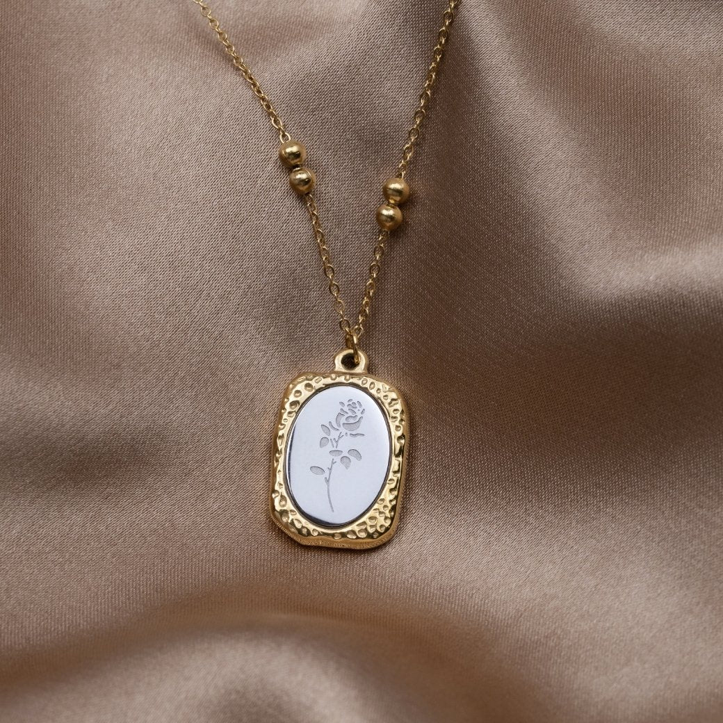 'Fragile Love' Rose Necklace, laid on draped satin, pendant with an engraved white rose