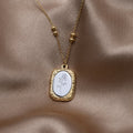 'Fragile Love' Rose Necklace, laid on draped satin, pendant with an engraved white rose