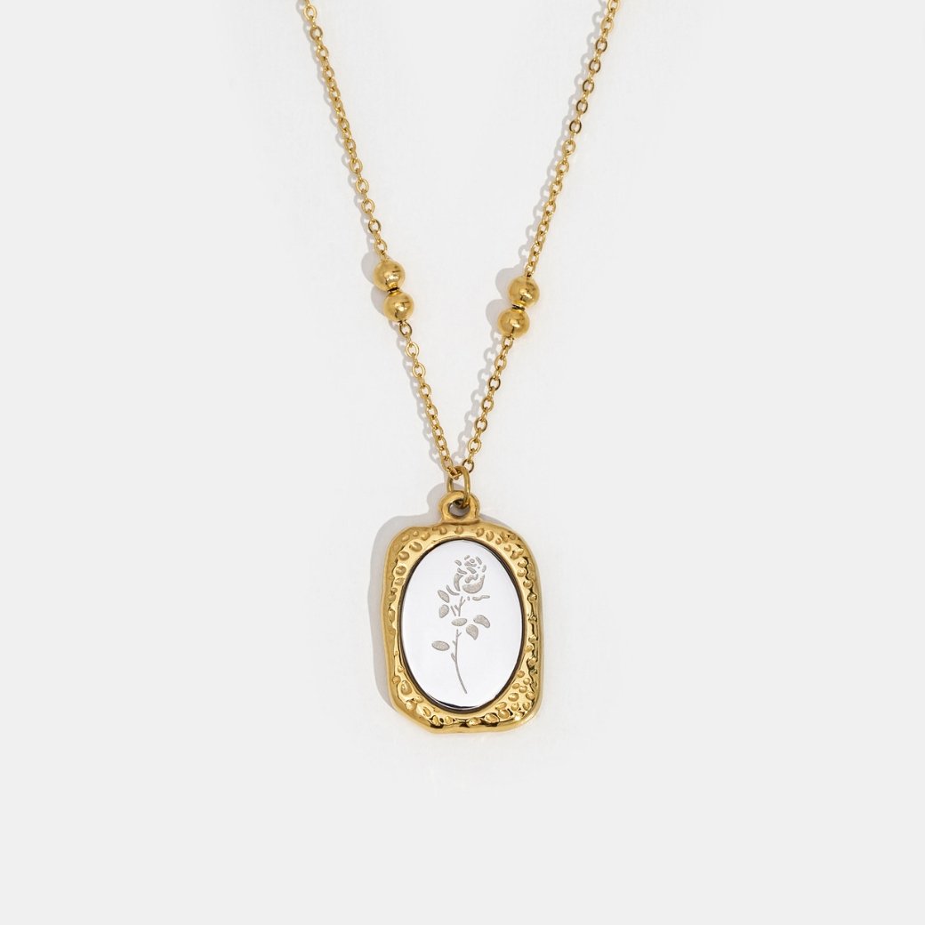 'Fragile Love' Rose Necklace, laid flat on white, gold pendant with white rose engraving
