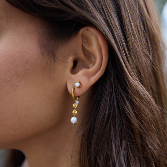 Free Sofia Pearl Stud Earrings, worn on an ear with a pearl stud and gold drop earring