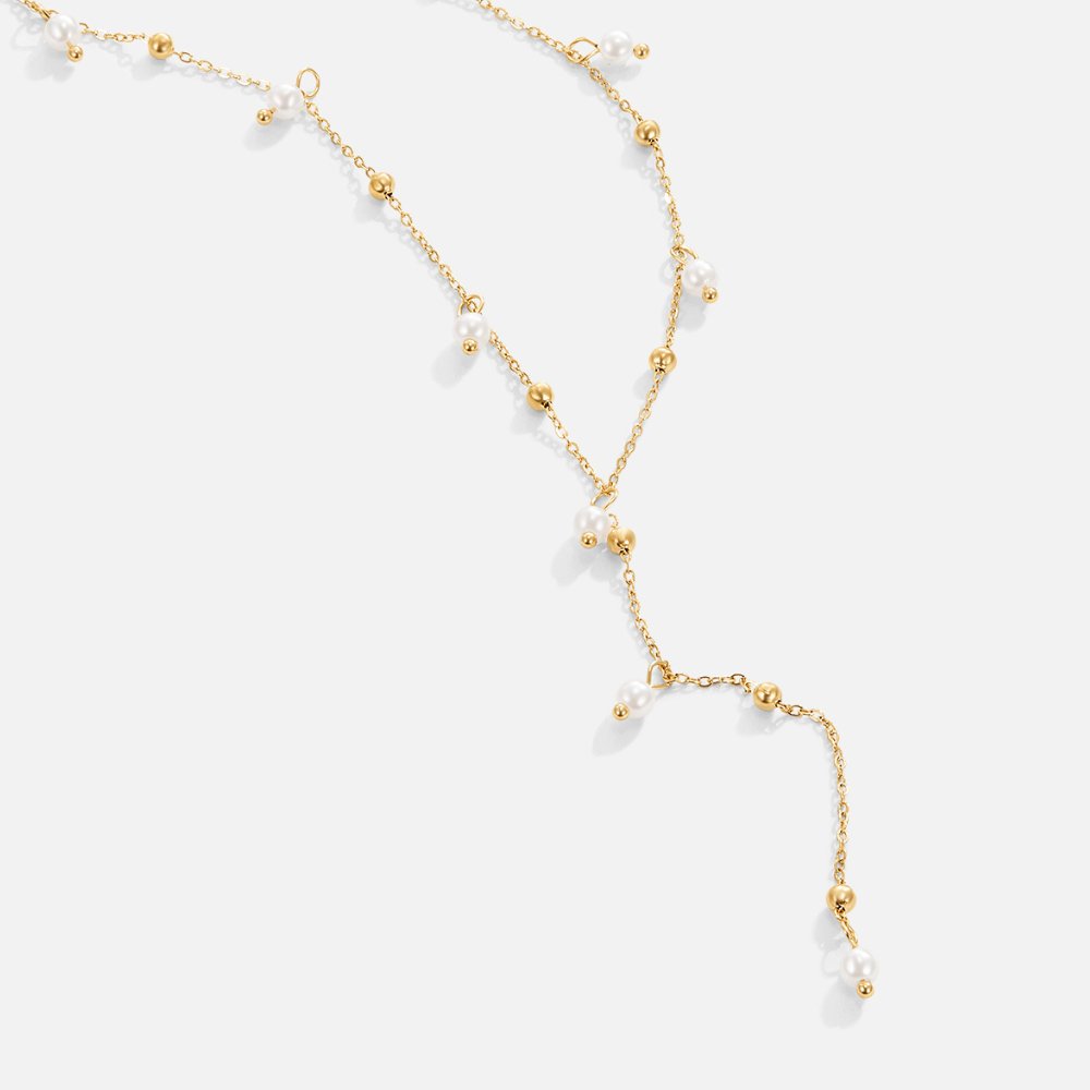 Lariat Pearl Drop Necklace, laid flat on white, long lariat with gold beads and pearls