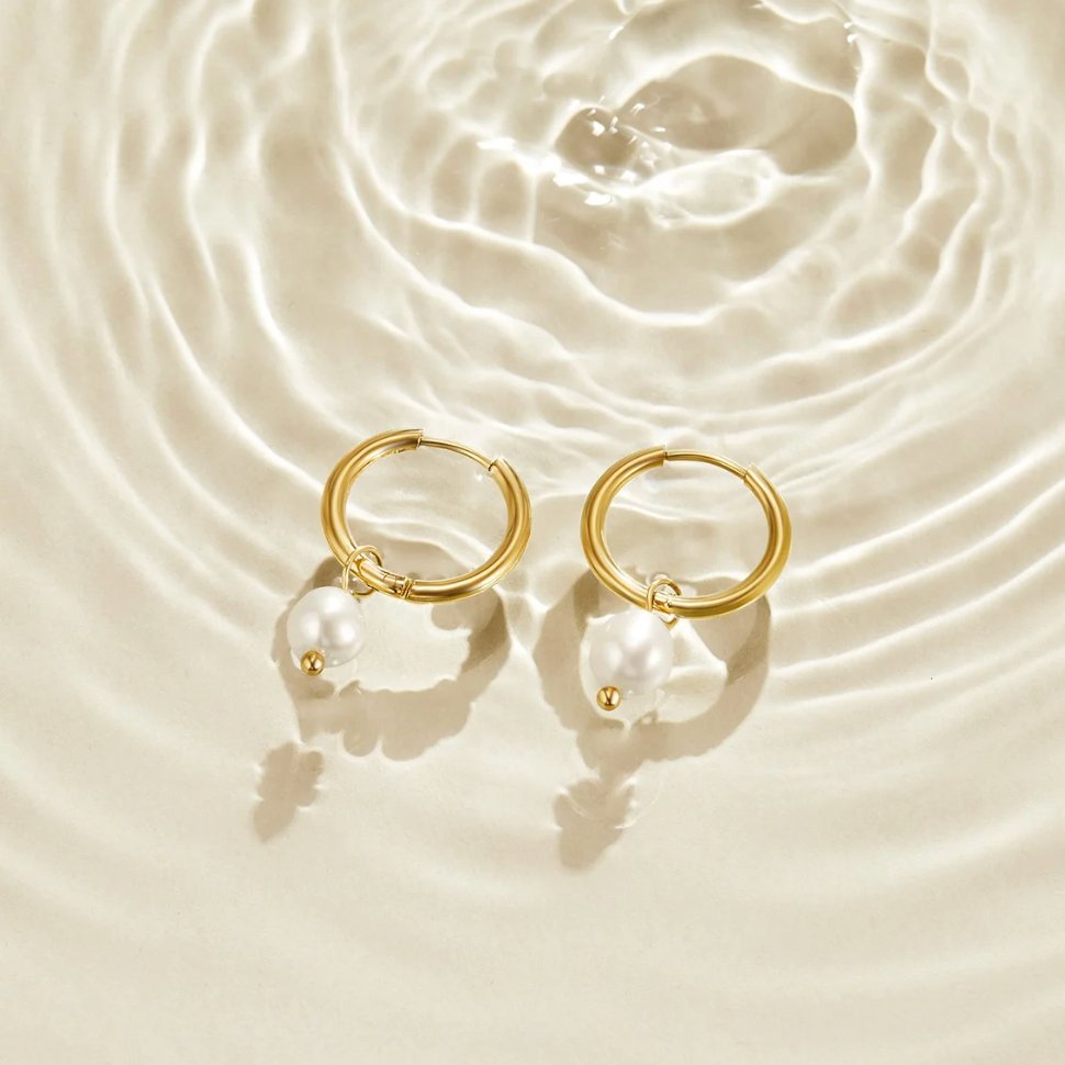 Freshwater Pearl Bella Hoop Earrings, a pair of gold hoops with pearl drops on rippled water