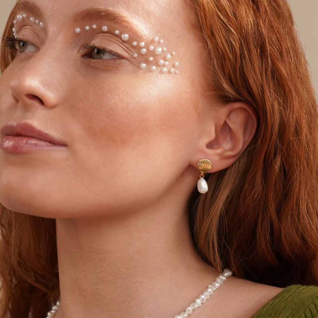 Freshwater Pearl & Gold Shell Earrings, worn on an ear with a pearl necklace, gold shell top