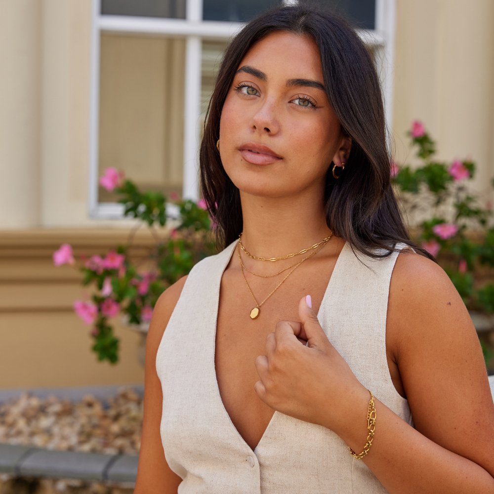 Geometric Pendant Necklace, worn on a model with layered gold chains and a bracelet