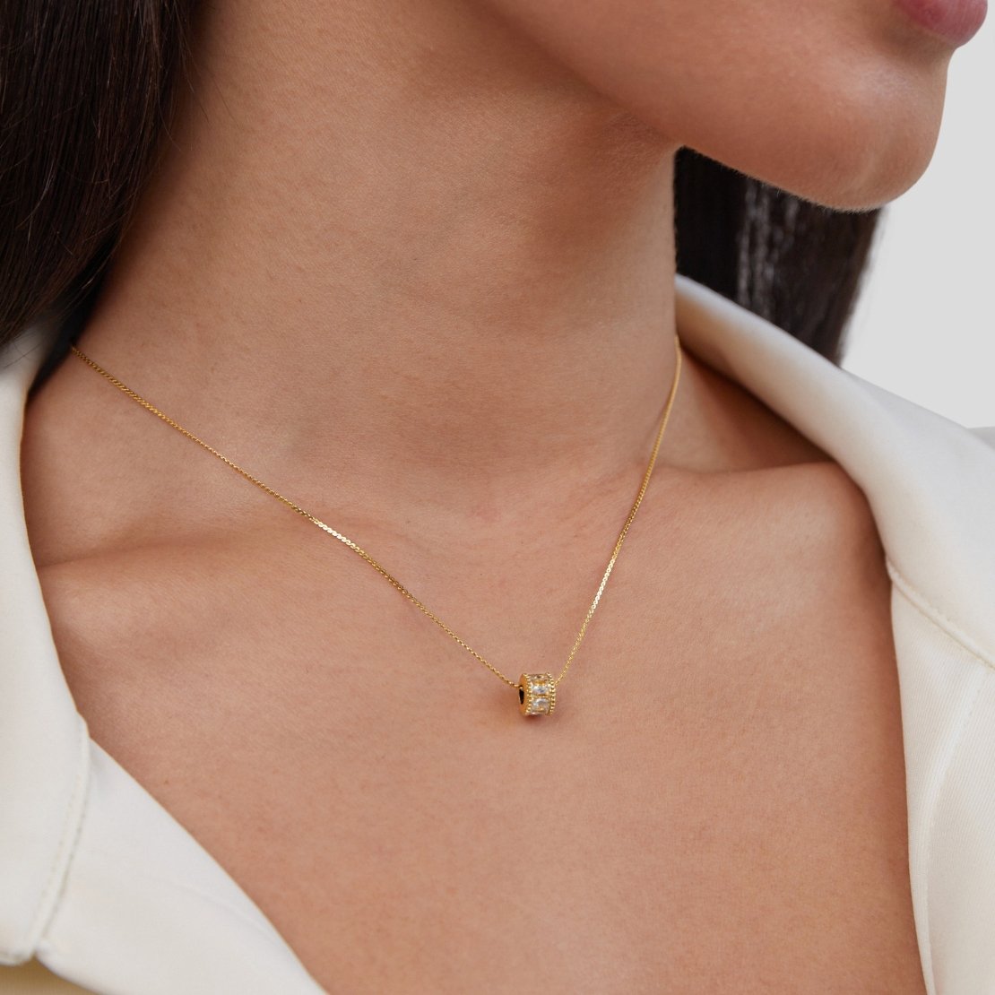 Gigi Crystal 18K Gold Necklace, worn on a neck with a white collared top, close-up on pendant