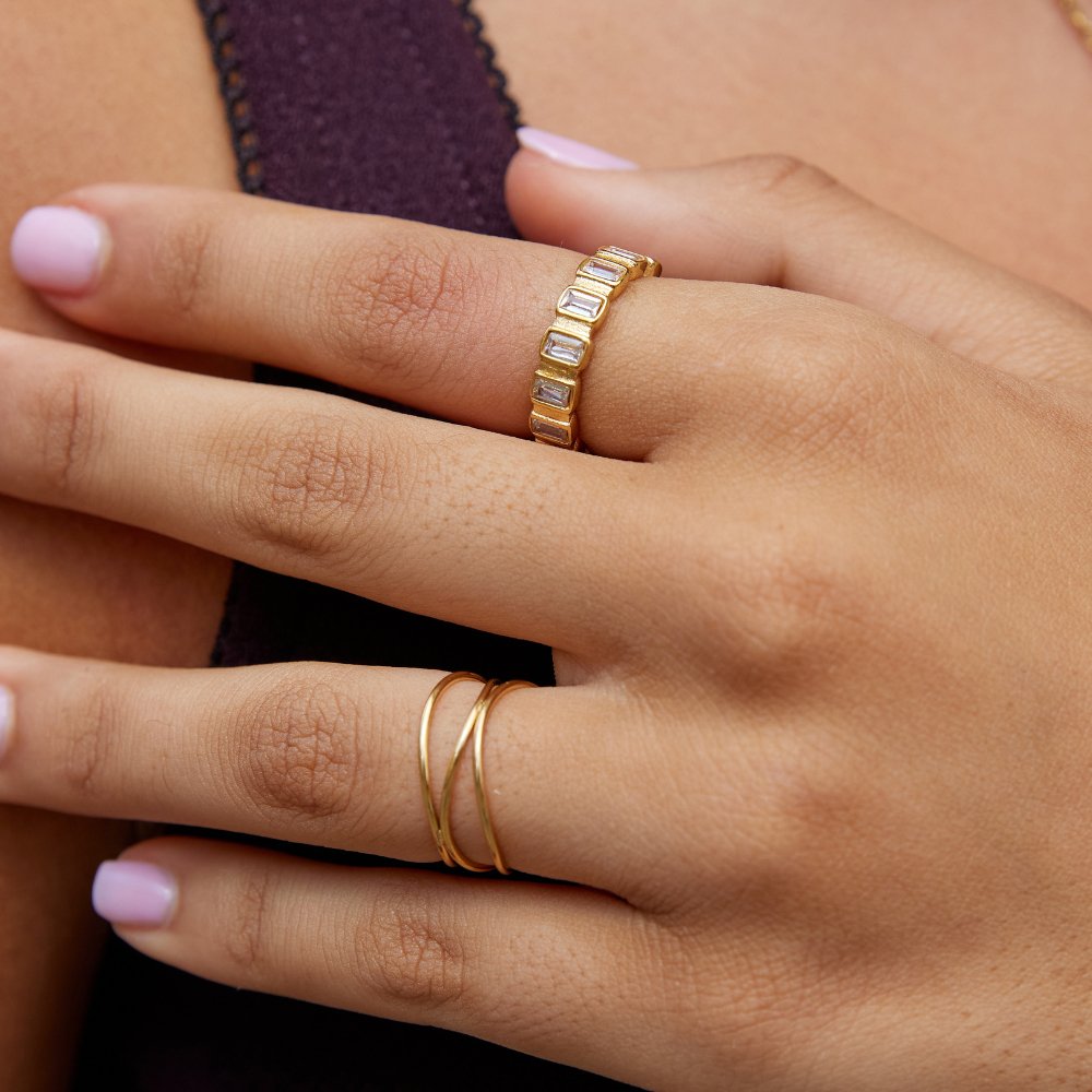 Gigi Square Crystal Ring, worn on a hand with a gold ring of baguette stones