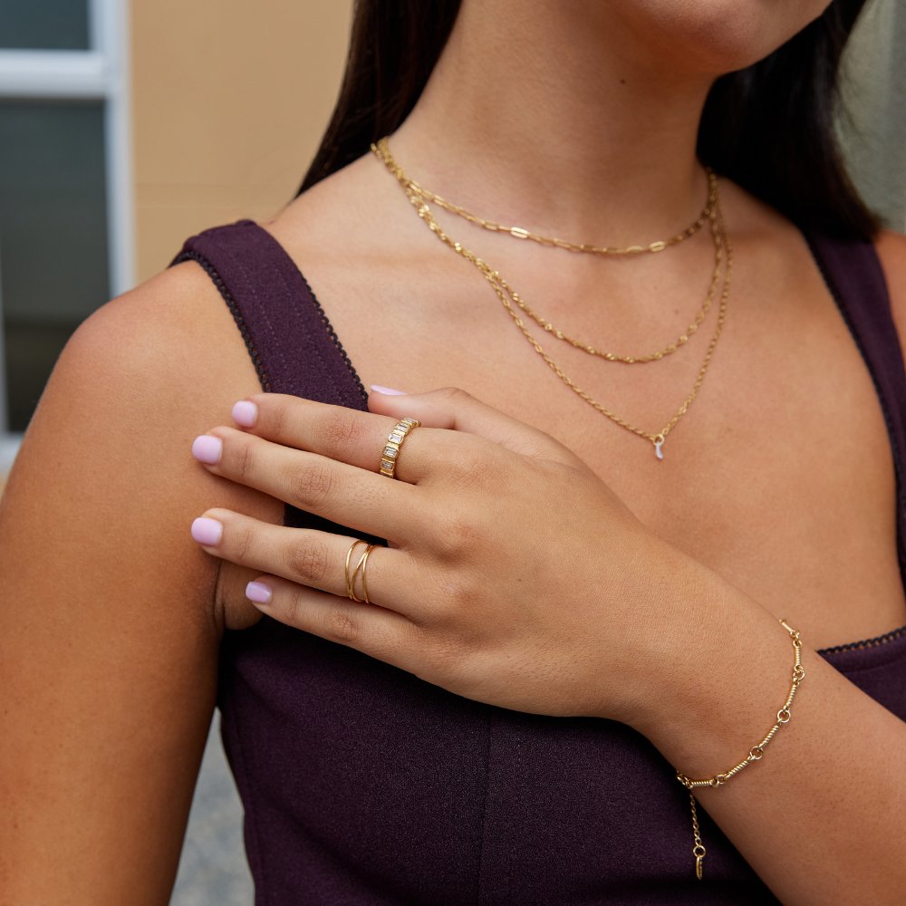 Gigi Square Crystal Ring, worn on a hand with layered gold necklaces and bracelet