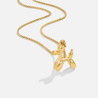 Gold Balloon Animal Necklace, gold balloon dog pendant on a box-link chain against white