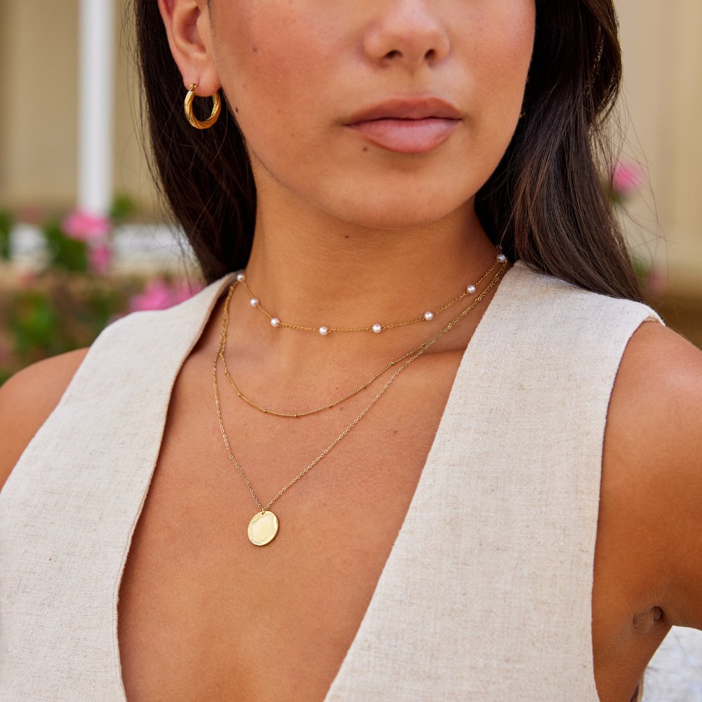 Gold Coin Necklace, worn layered at the neck with pearl chain and hoop earring