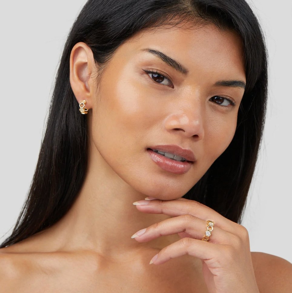 Gold & Crystal Honeycomb Ring, worn on a model's hand under her chin, with matching earring
