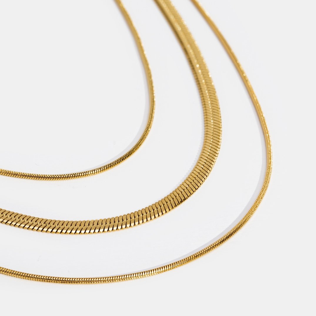 Gold Multi-Layered Chain Necklace, three layered gold snake chains on a white background