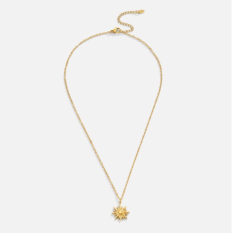 Golden Sunburst Necklace, flat lay of gold chain with sunburst pendant and extender