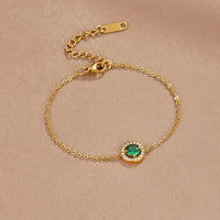 Green Emerald Crystal Bracelet, laid flat on beige satin, green stone with diamond-set halo