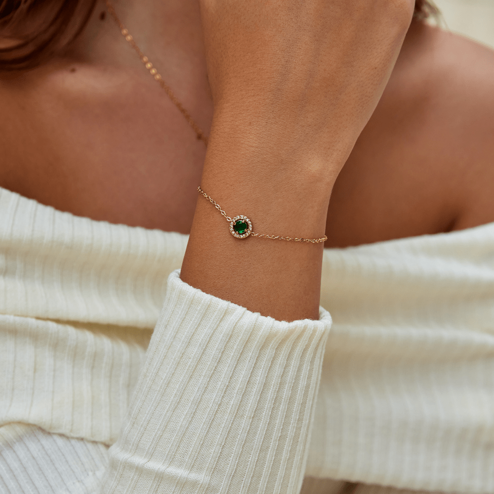 Green Emerald Crystal Bracelet, worn on a wrist with a cream knit sweater, green centre stone