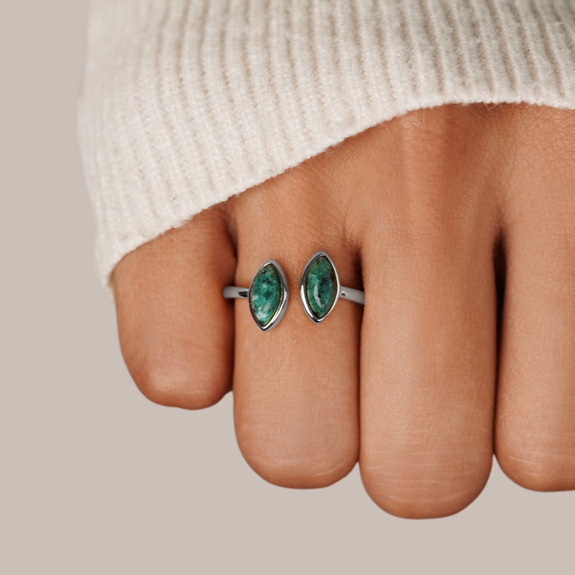 Silver Jade Green Wrap Ring, worn on a finger in a cream knit sleeve, silver band