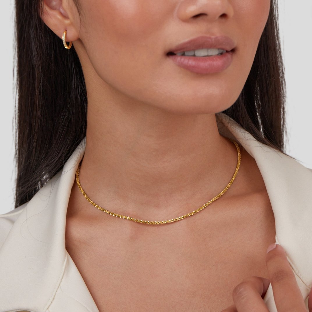 Kai 18K Gold Necklace, worn on a model with a white collared top, gold hoop earring