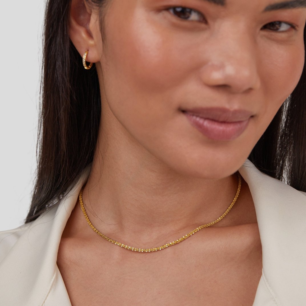 Kai 18K Gold Necklace, worn on a model with a gold hoop earring and white collar