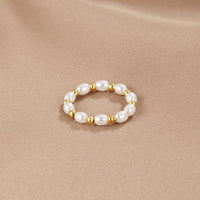 Kai Mini Pearl Ring, ring lying flat on a beige satin cloth, pearls alternating with gold beads