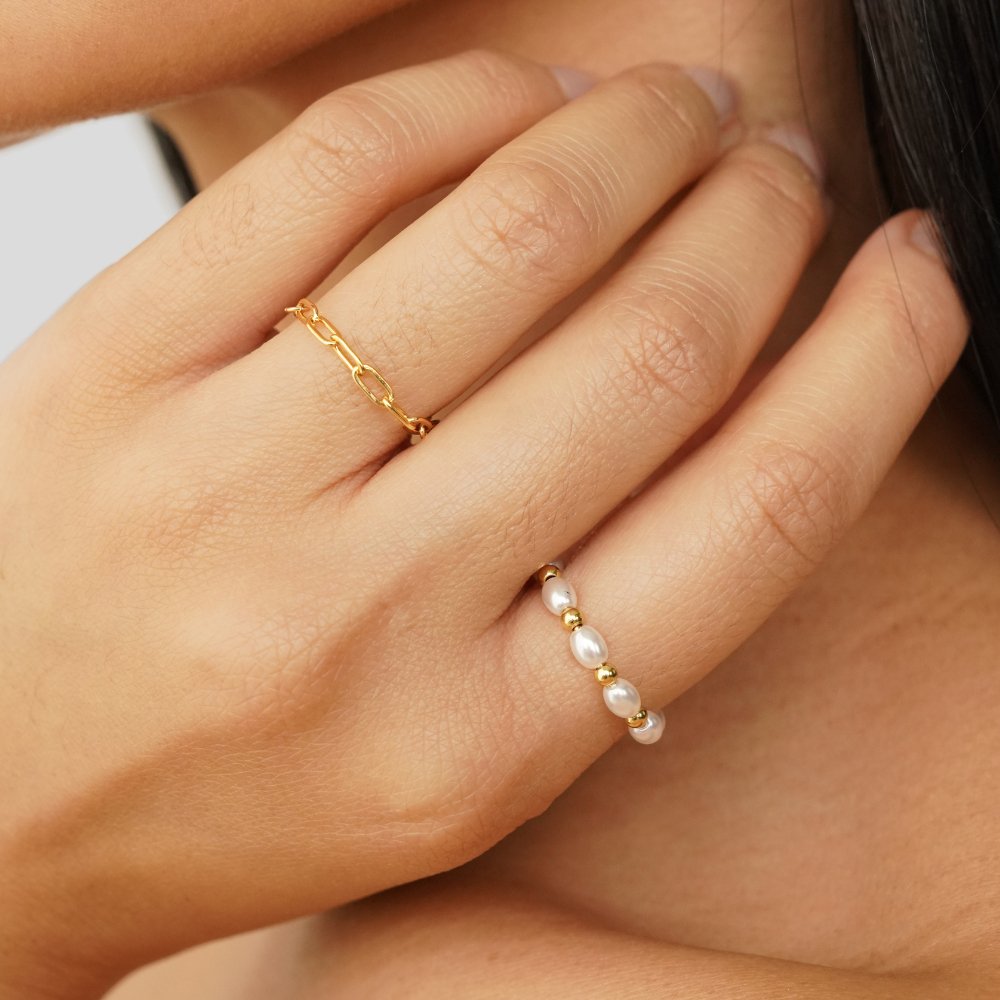 Kai Mini Pearl Ring, worn on a hand with a gold chain ring, close-up on fingers