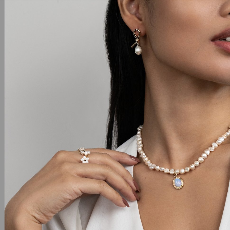 Knotted Gold & Freshwater Pearl Earrings, worn on a model with a pearl necklace and pearl ring