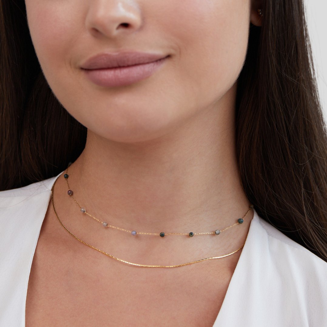 Layered Alana Gold & Stone Necklace, worn layered on a neck with a white top, close crop of the face