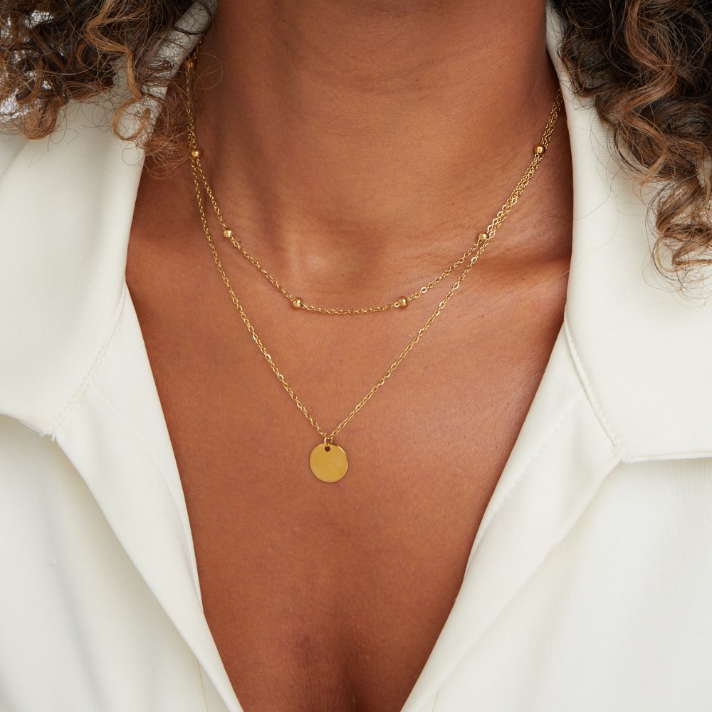 Layered Disc Necklace, worn on a neck over a white collared shirt, gold disc pendant