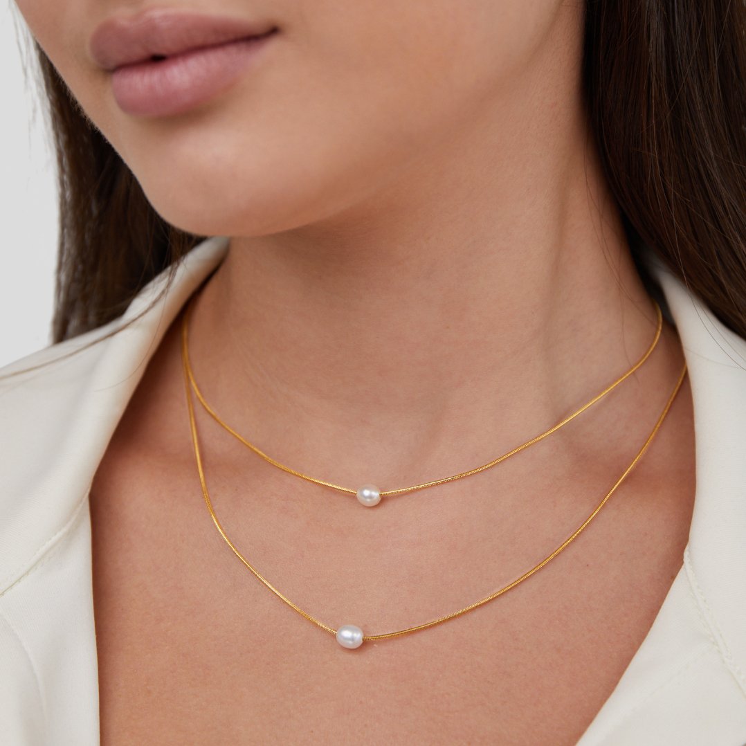 Layered Freshwater Pearl Necklace, worn layered at the neck with a white top, gold chains and pearls