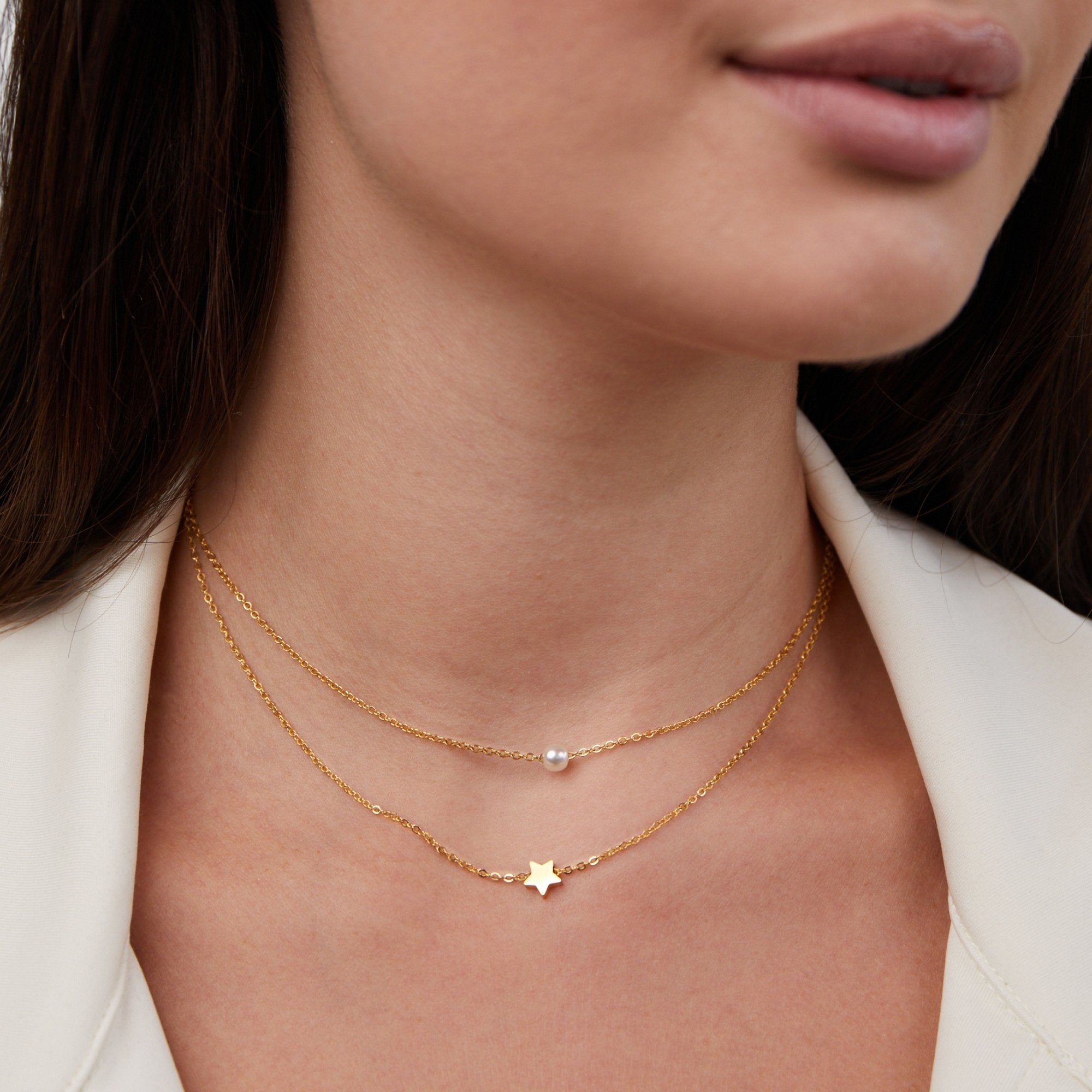 Layered Gold Star & Pearl Necklace, worn on a neck with a white jacket, pearl and gold star