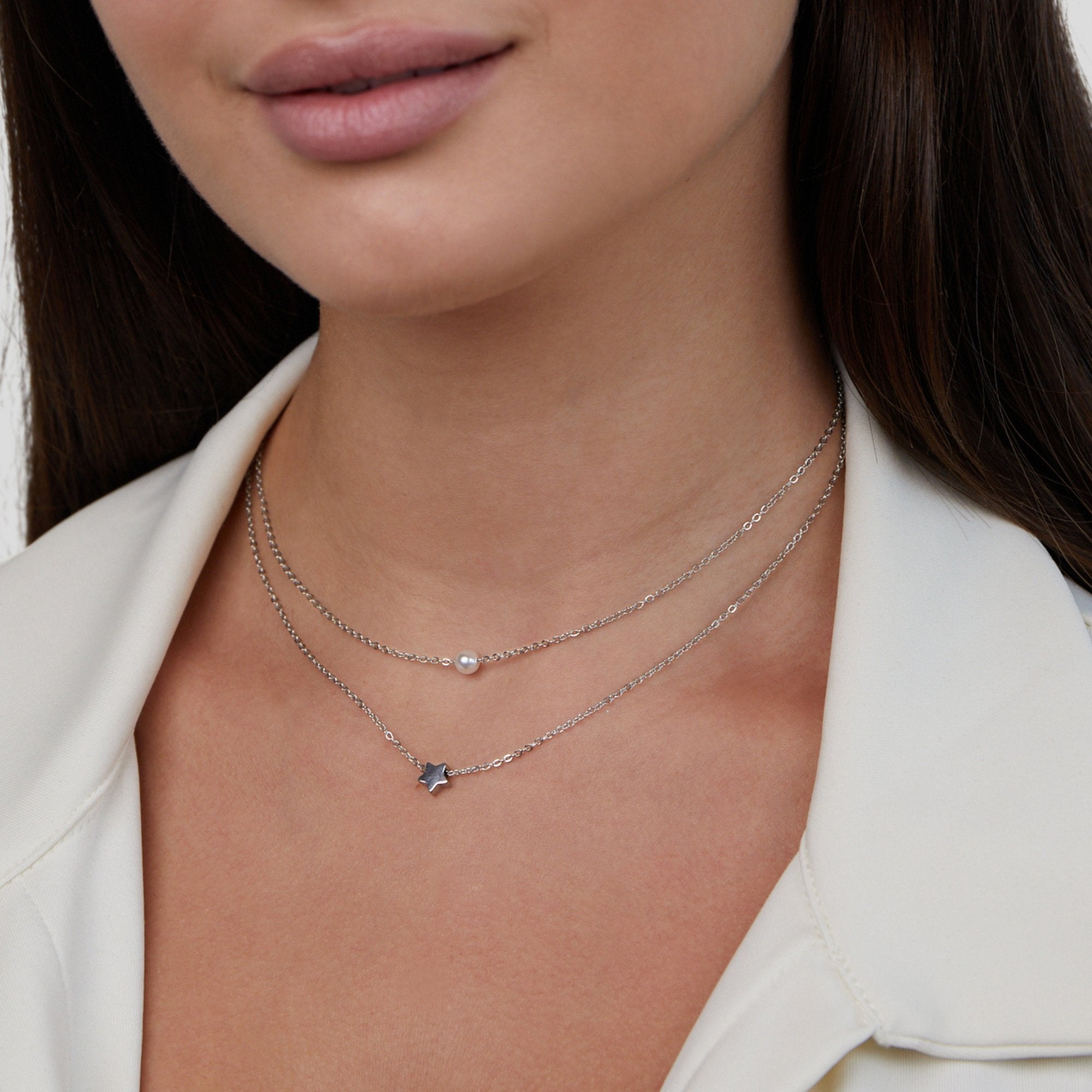 Layered Silver Star & Pearl Necklace, worn on a neck with a white collared top, two layered chains