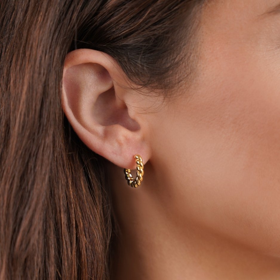 Layla Gold Twist Earrings, worn in one ear, close-up of a twisted gold hoop