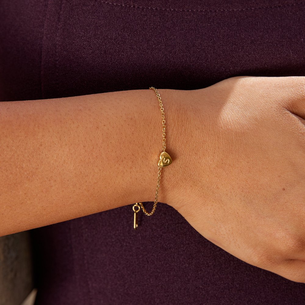 Letter Heart Bracelet, worn on a wrist with a small gold heart charm