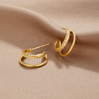 Leyla Crystal Double Hoop Earrings, pair of gold double hoop earrings on beige fabric, one