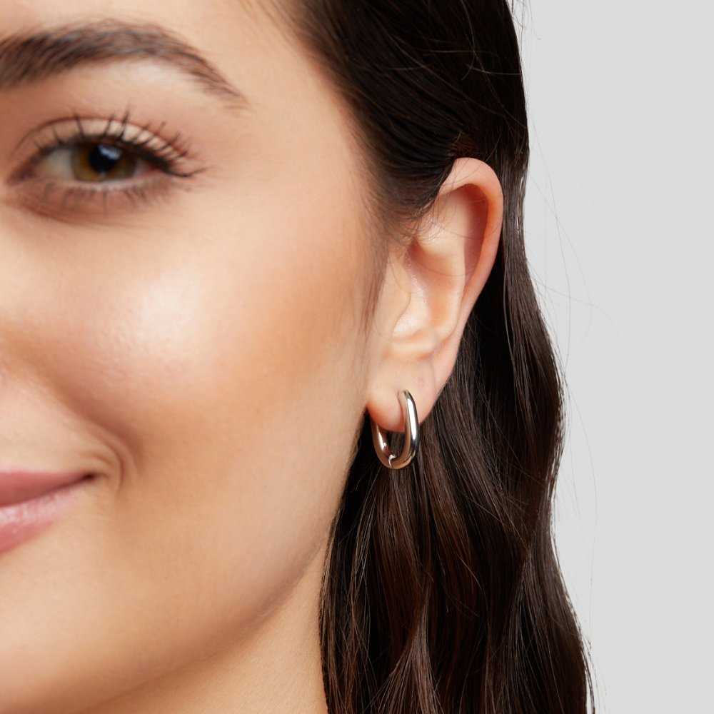 Madison Silver Hoop Earrings, worn on an ear, close-up with polished silver hoop
