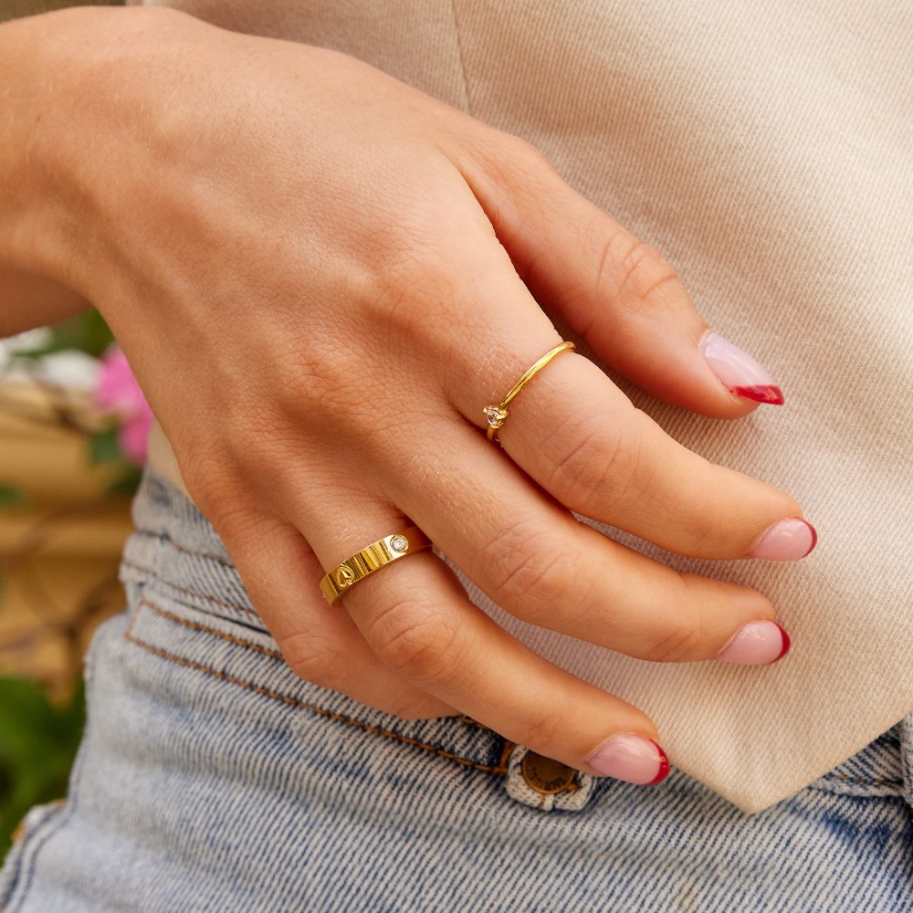 Mari Heart Gold Ring, worn on a hand with a thin gold ring and a wide ridged band
