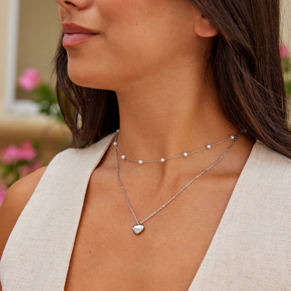 Marina Love Silver Necklace, worn on a neck with a layered chain and small heart pendant