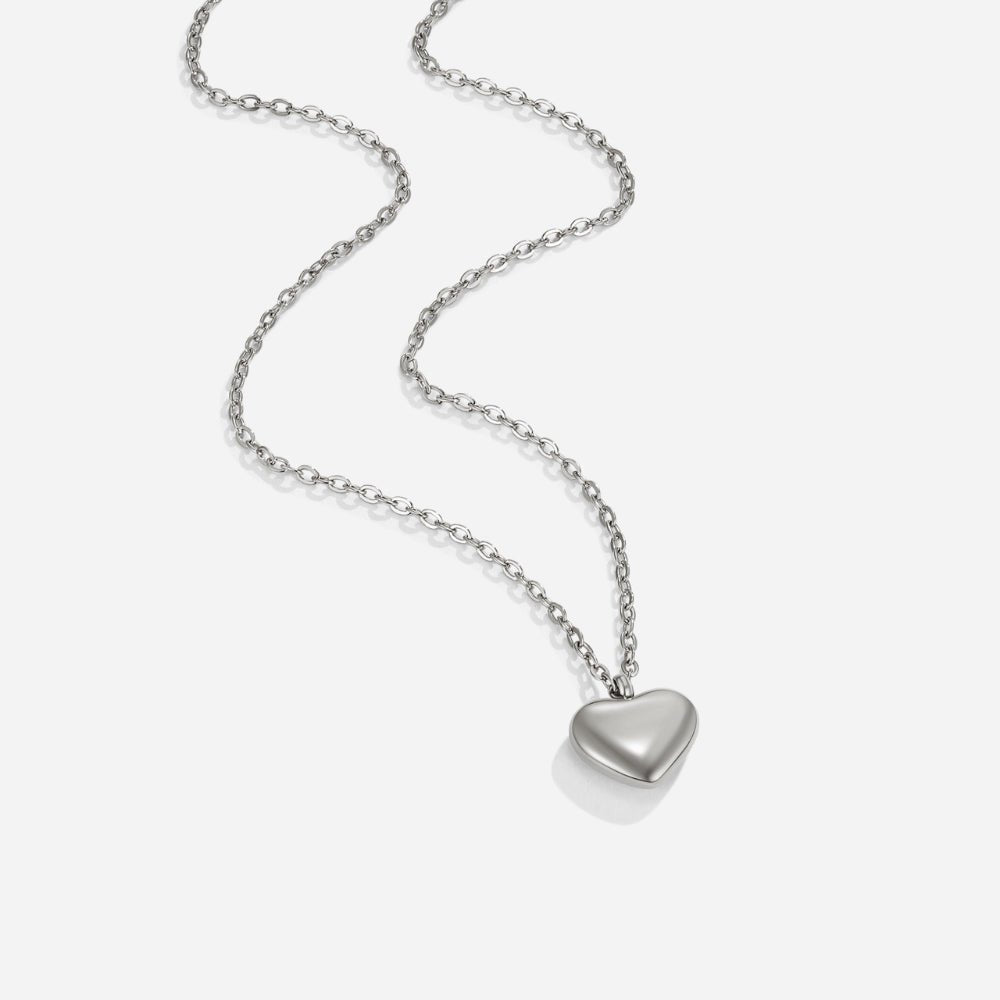 Marina Love Silver Necklace, silver chain necklace laid on white, with a polished heart pendant
