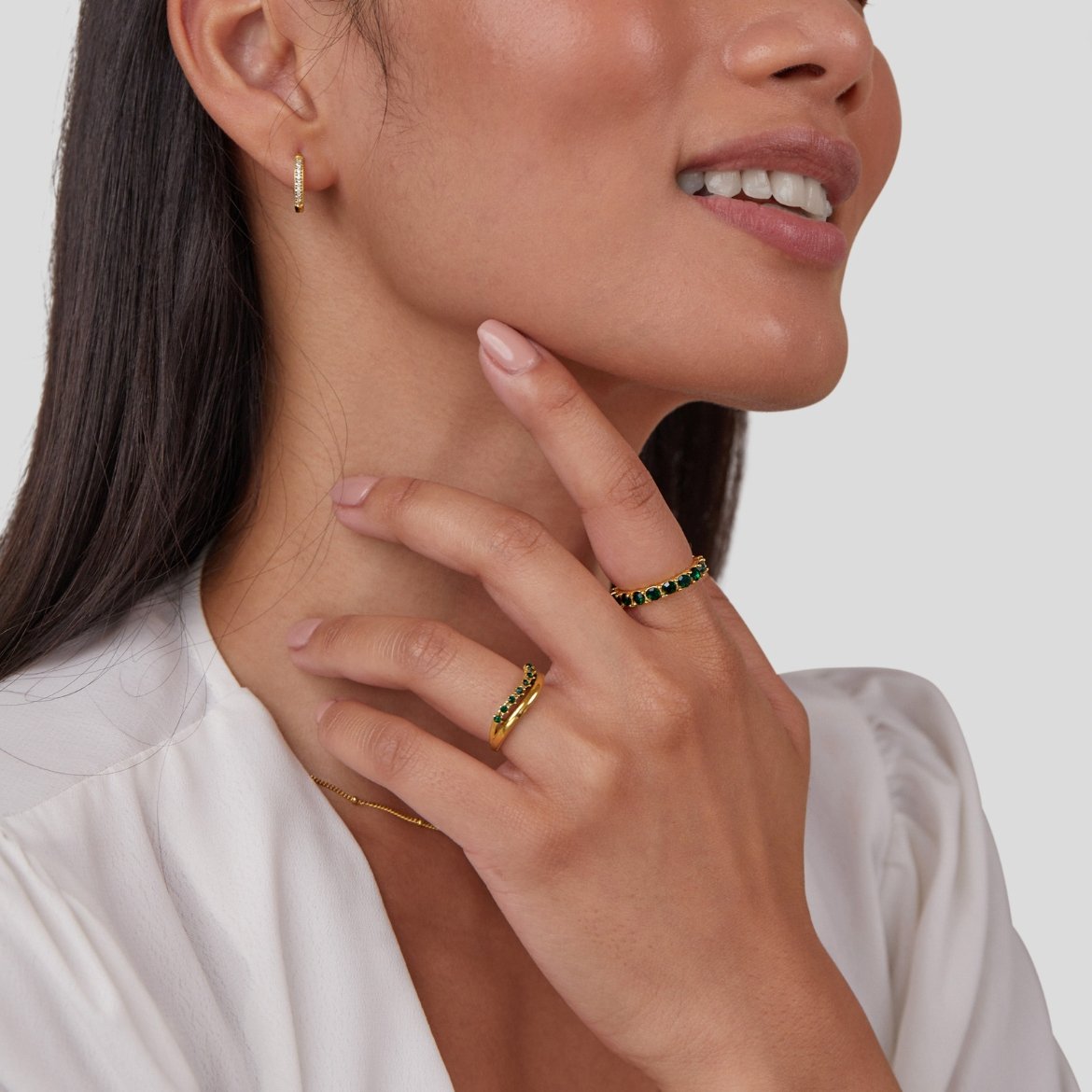 Marissa Emerald Green Layered Ring, worn on a hand with a gold hoop earring and white top
