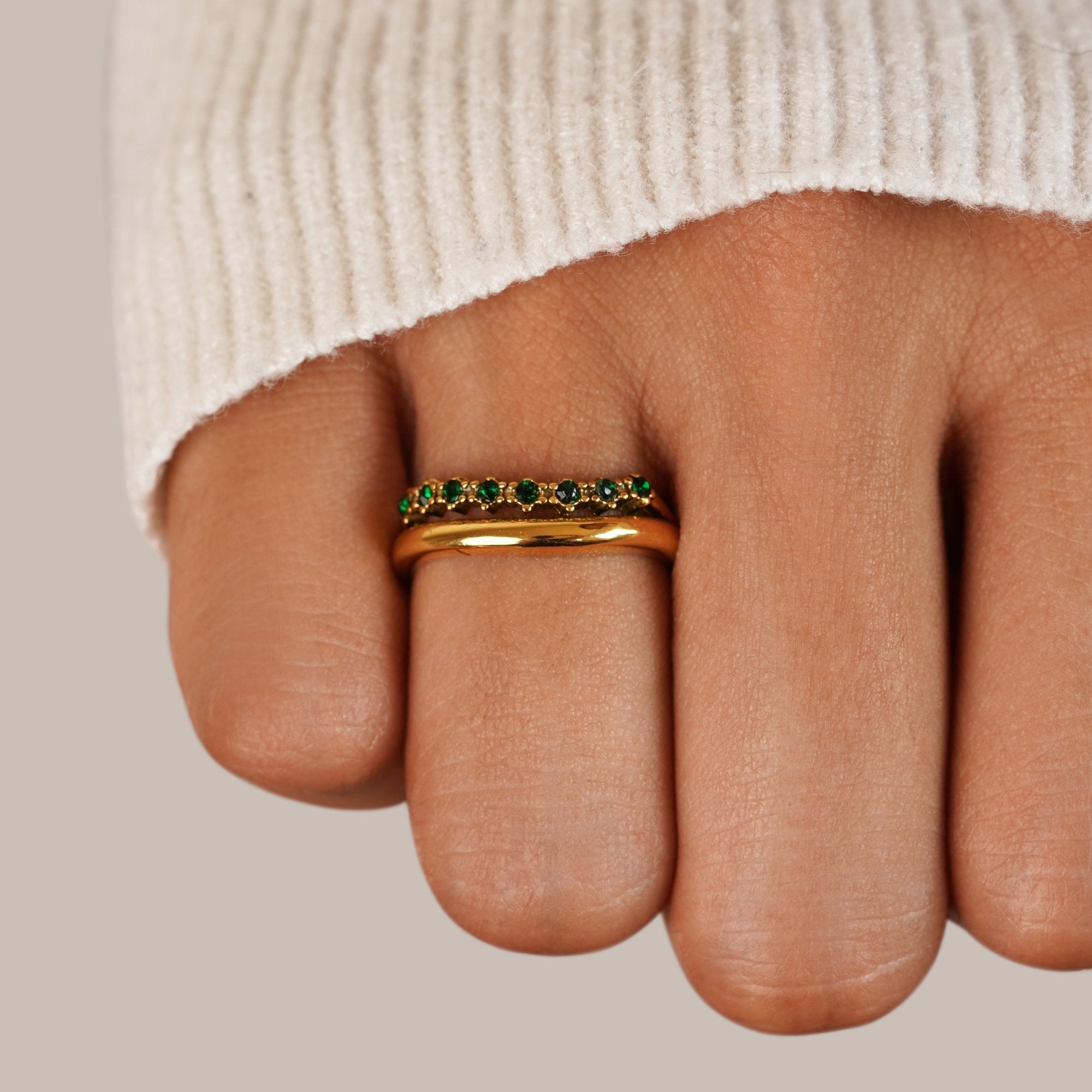 Marissa Emerald Green Layered Ring, worn on a finger with a cream knit sleeve, green stones