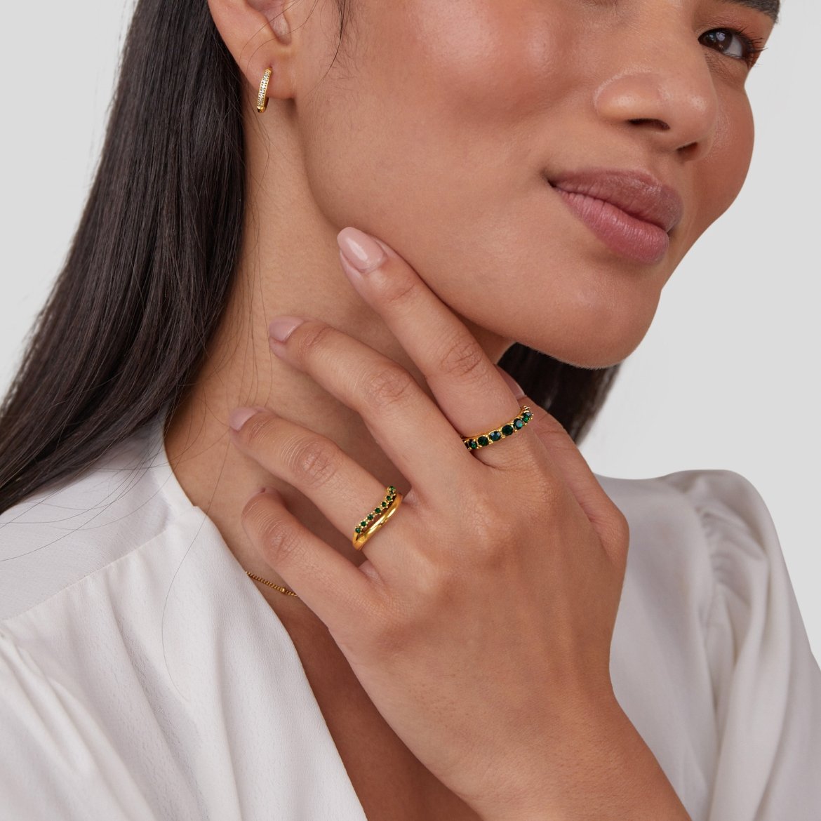 Marissa Emerald Green Layered Ring, worn on a hand with gold hoop earring and white top