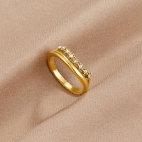 Marissa White Crystal Layered Ring, gold ring with a row of small crystals, resting on beige fabric