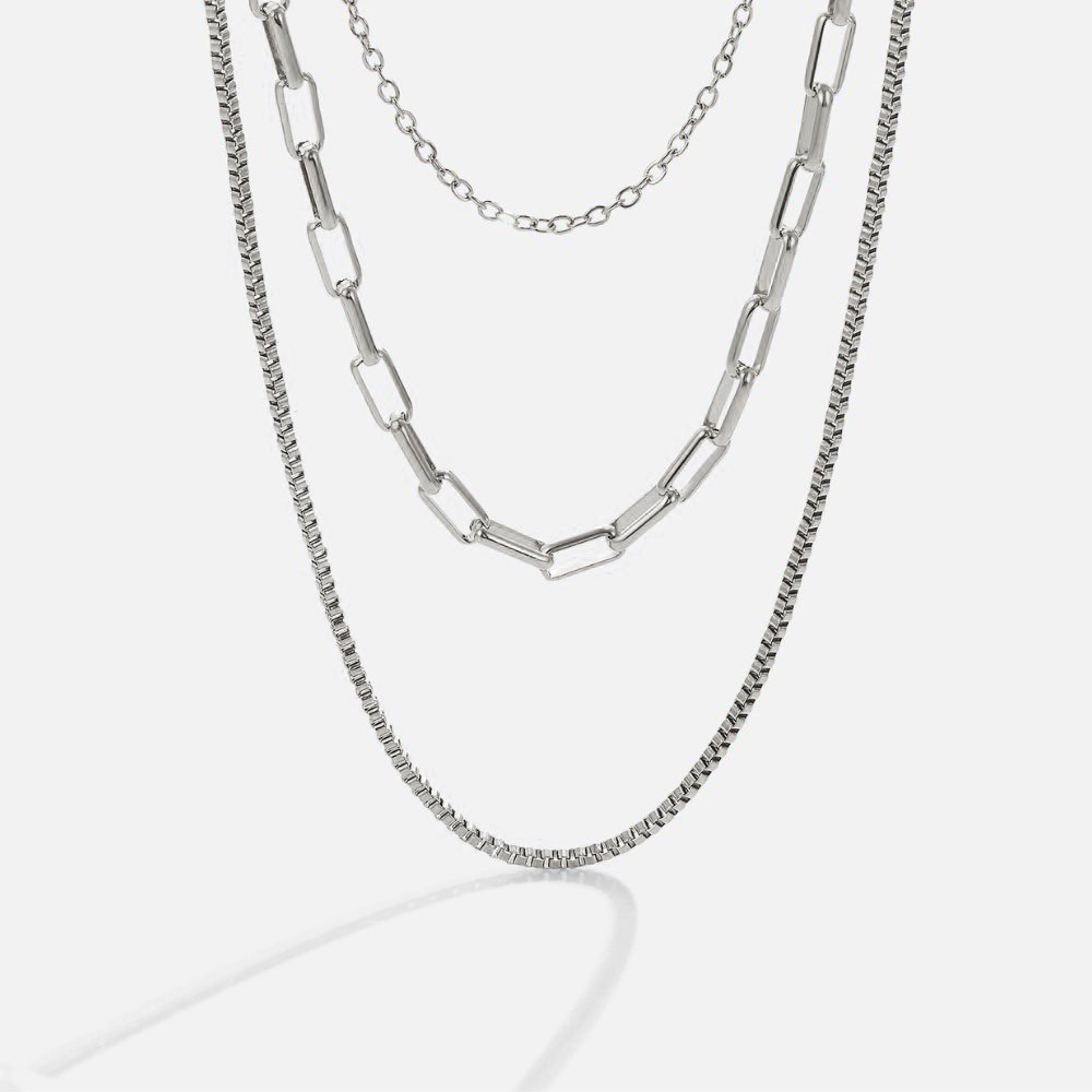 Miela Layered Chain Necklace, three silver chains layered together, against a plain light