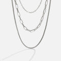 Miela Layered Chain Necklace, three silver chains layered together, against a plain light