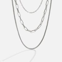 Miela Layered Chain Necklace, three silver chains layered together, against a plain light