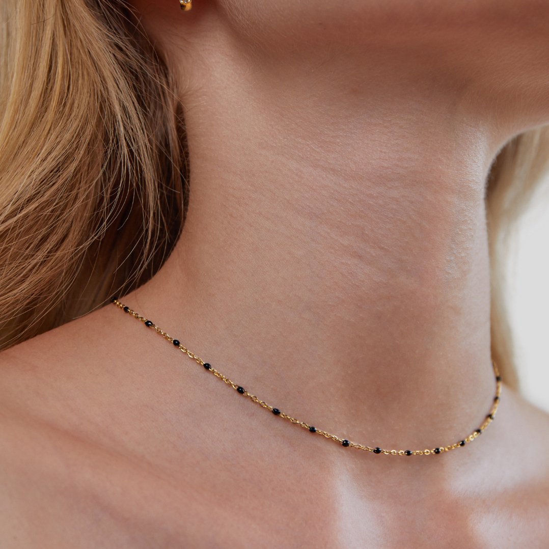 Mila Black Bead Necklace, worn at the neck with black beads spaced along gold chain