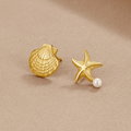 Naia Shell & Starfish Gold Earrings, pair of gold shell and starfish stud earrings on beige