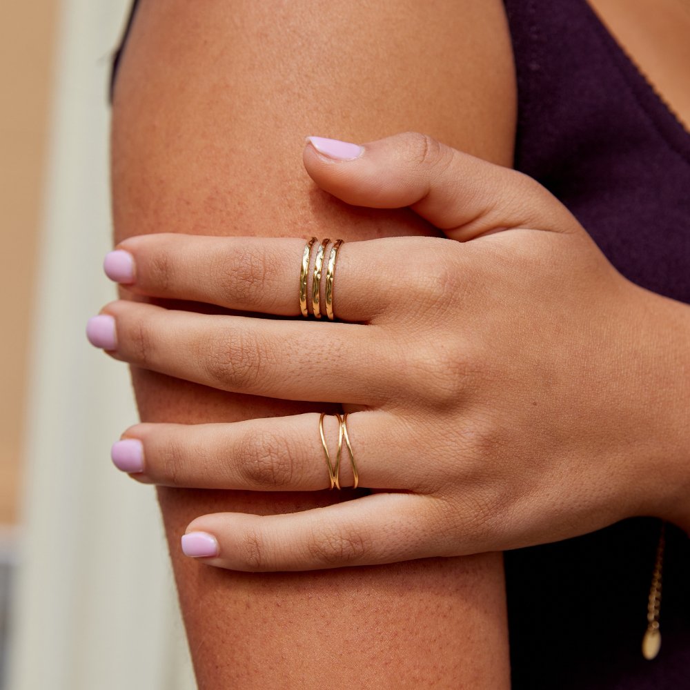 Ohio Layered Gold Ring, worn on a hand resting on an arm, pink nails, gold rings